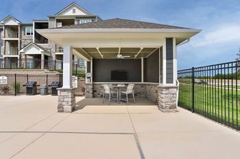 A patio with a table and chairs under a pavilion